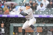 Yankees shortstop Anthony Volpe was batting in a thunderstorm when Sunday's game at Coors Field was stopped in the fifth inning. Play resumed after a 1-hour, 46-minute play.