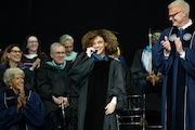 Olympic gymnast Laurie Hernandez bites the medal she was presented in recognition of her service as commencement speaker during Kean University's graduation ceremony for the Class of 2025 on Tuesday, May 13 at the Prudential Center in Newark.