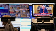 A trader sits in front of computer screens on the trading floor of the Frankfurt Stock Exchange beside a TV showing U.S. President Donald Trump on a news channel in Frankfurt, Germany, the day after Trump's announced a 90-day pause on 'reciprocal' tariffs, Thursday, April 10, 2025. (AP Photo/Martin Meissner)